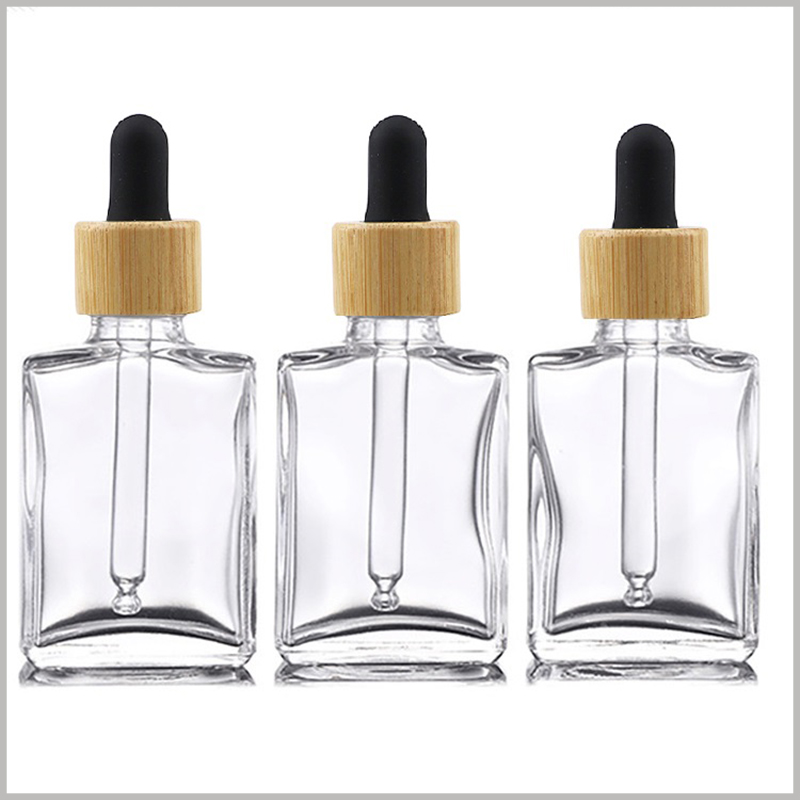 Flat square clear essential oil dropper bottle wholesale. clear essential oil glass bottle with wooden ring and black rubber cap.