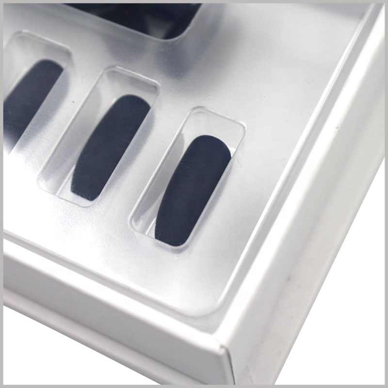 White cardboard nail boxes with clear blister. The blister pack is placed inside the box to fix the black false nails in a specific position, arranged and displayed in a specific way.
