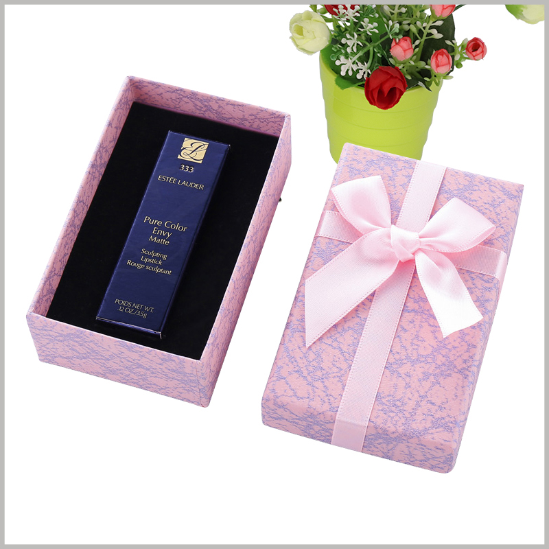 custom lipstick gift boxes wholesale. The top cover of the customized cardboard gift package is decorated with pink silk gift bows, and the whole package is more valuable as a gift.